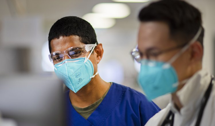 Two doctors in masks looking at computer